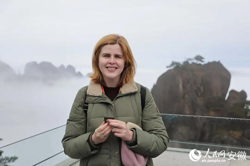 美國旅行商貝愛然與背后的云海合影。